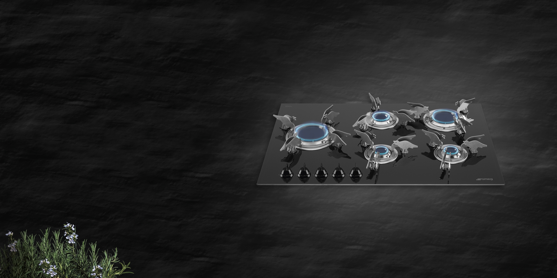 Dolce Stil Novo aesthetic gas hob featuring a black glass surface and sculptural metallic burners, photographed against a dark textured background