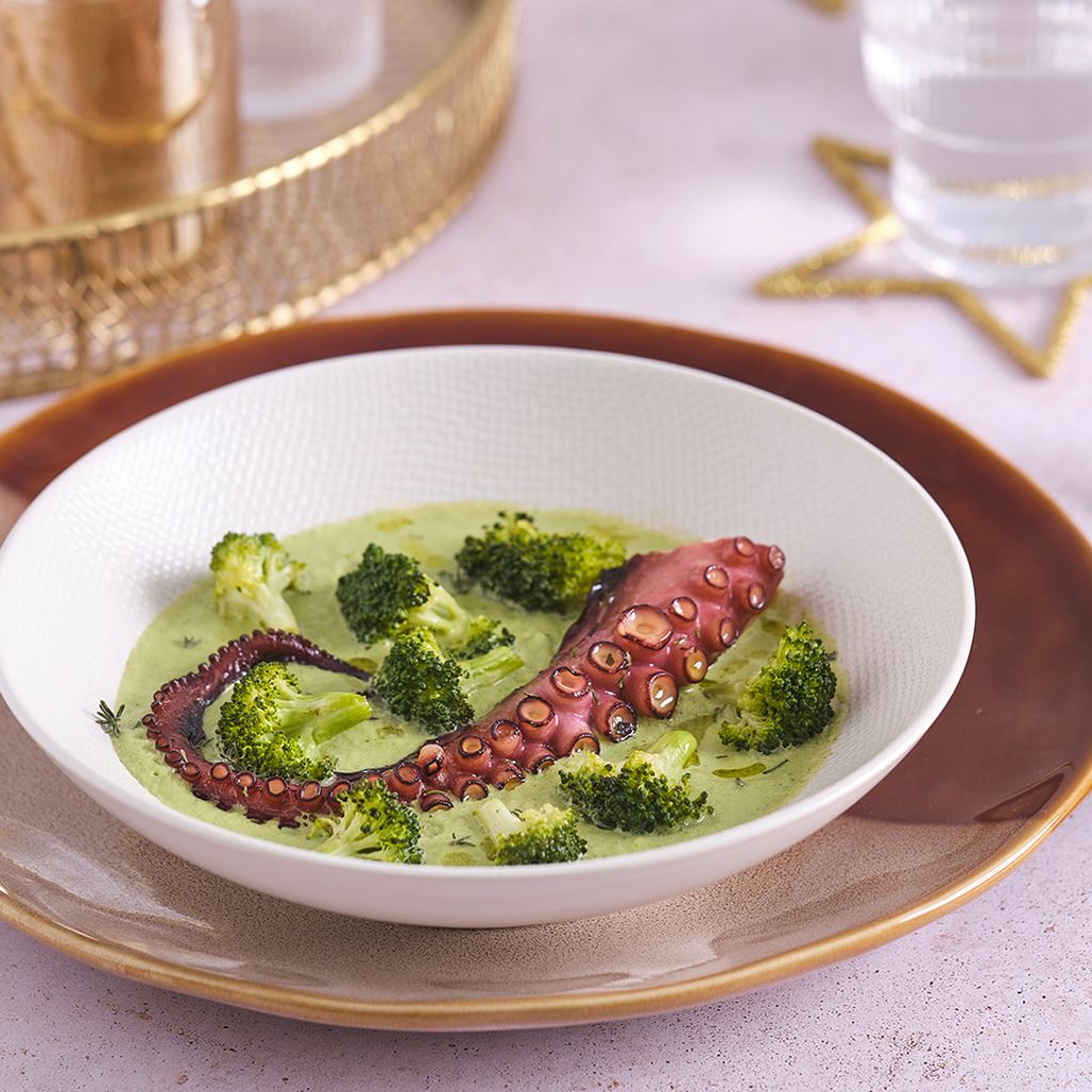 Octopus tentacle served on creamy broccoli purée with fresh florets in a refined plated presentation
